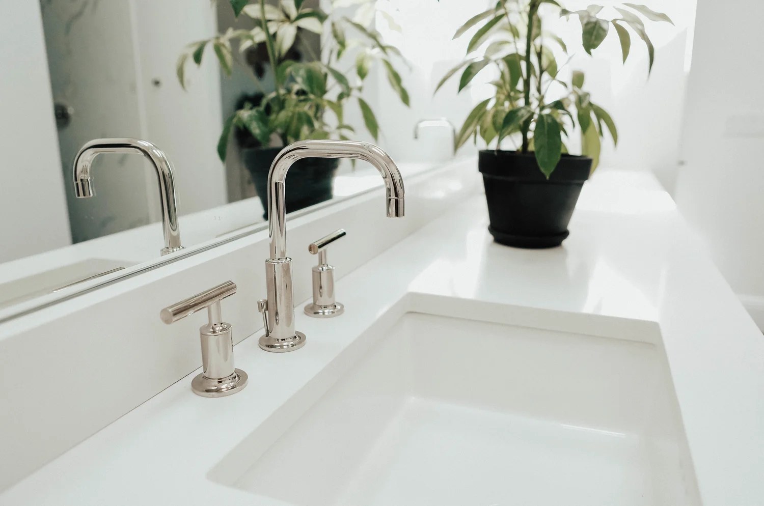 Bright, clean bathroom with a polished chrome faucet and white stone sink